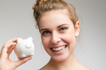 young happy girl with a piggy bank