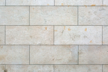 Texture of a wall of non uniform textured stone blocks with flat cuts. Grunge and dirty look with modern face.