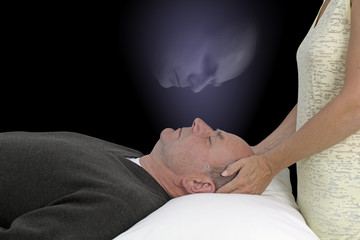 Higher Self Healing Session - Female healing practitioner giving supine male client energy with...