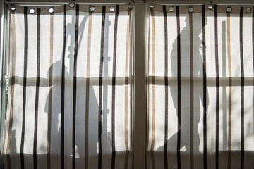 Silhouette di operai sulla tenda della finestra