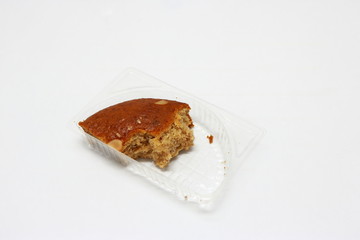 A piece of cake, closeup part of almond banana cake in plastic box, selective focus. Banana cake is...