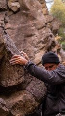 Half man face practising bouldering on rock