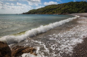 Crashing waves at Pwll Du Bay on the Gower peninsula in Swansea, South Wales, UK, once an extensive limestone quarry and also a popular smuggling cove.