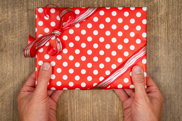 Hands holding craft paper gift box