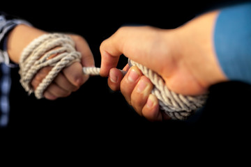 Two hands one wearing a blue shirt while the other wearing black and white square pattern shirt and...