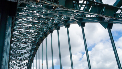 Internal image of the green painted steel structure featuring the arch of the Tyne Bridge in Newcastle upon Tyne taken against a contrasting summer sky.