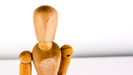 Artist wooden mannequin looking inquisitively at the camera, isolated with a white background.