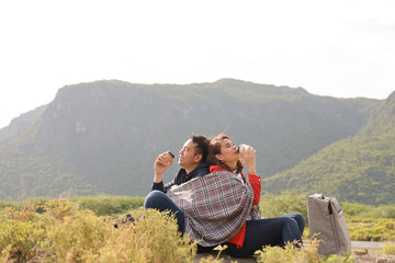 Fototapeta na wymiar Asian couple drinking coffee travel in winter time mountain view background