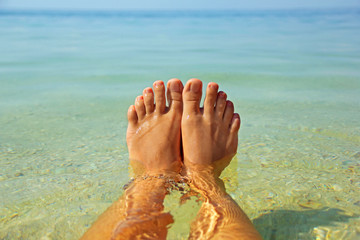 Fototapeta na wymiar Beautiful female legs in the water. Summer. Relaxation