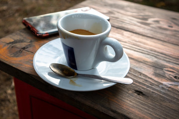 Small cup of espresso coffee on primitive wooden table