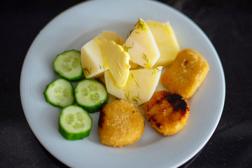 boy eating simple and cheap food for children - nuggets, cucumbers and potatoes