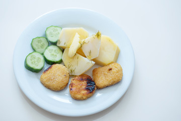 boy eating simple and cheap food for children - nuggets, cucumbers and potatoes