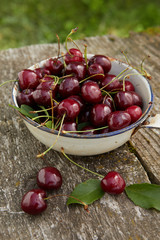 close up view of nice fresh red cherry with leaf on wooden background