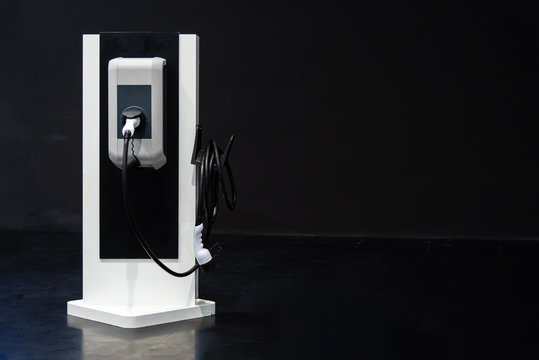 Electric vehicle charger ( EV ) station for charging electric car isolated on black background.