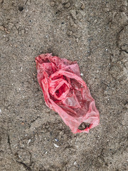 Plastic pollution on the beach. Single use plastic bag in sand top view, marine trash on the beach. Stop plastic pollution. Ban polyethylene bags. Rubbish. Garbage at coast