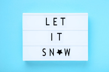 Lightbox with words Let It Snow on blue background