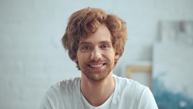 young redhead man smiling and nodding at home