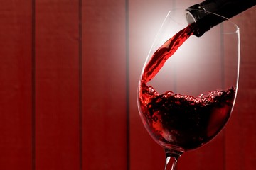 Red wine being poured in wineglass, closeup