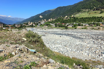 Landscape views of the Caucasus Mountains, river and villages. Peak and river Enguri. Georgia. Summer. 2019