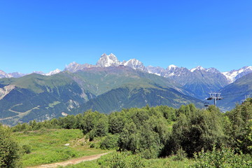 Landscape views of the Caucasus Mountains, river and villages. Peak and river Enguri. Georgia. Summer. 2019