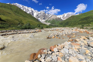 Landscape views of the Caucasus Mountains, river and villages. Peak and river Enguri. Georgia. Summer. 2019