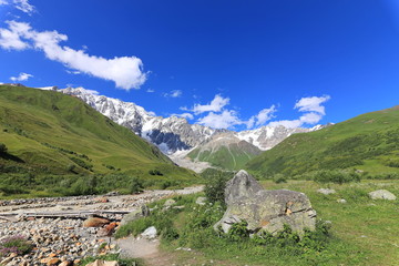 Landscape views of the Caucasus Mountains, river and villages. Peak and river Enguri. Georgia. Summer. 2019