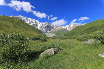 Landscape views of the Caucasus Mountains, river and villages. Peak and river Enguri. Georgia. Summer. 2019