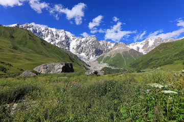 Landscape views of the Caucasus Mountains, river and villages. Peak and river Enguri. Georgia. Summer. 2019