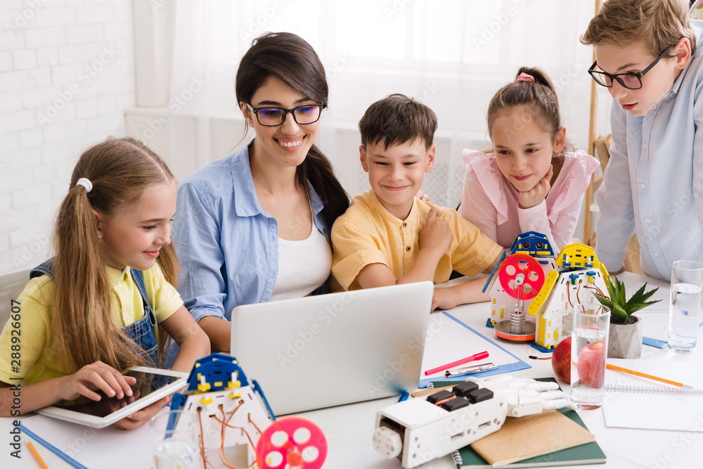 Poster Kids learning about computers and robots with their teacher