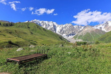 Landscape views of the Caucasus Mountains, river and villages. Peak and river Enguri. Georgia. Summer. 2019