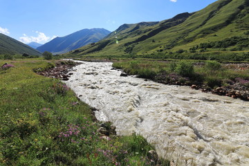 Landscape views of the Caucasus Mountains, river and villages. Peak and river Enguri. Georgia. Summer. 2019