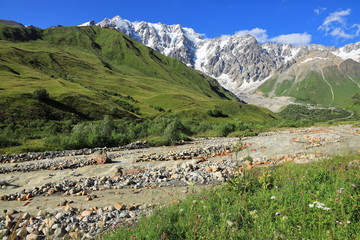 Landscape views of the Caucasus Mountains, river and villages. Peak and river Enguri. Georgia. Summer. 2019