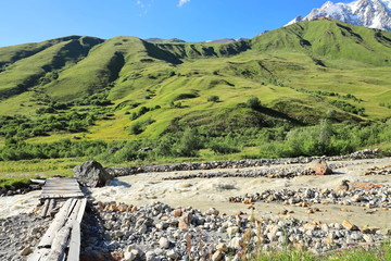 Landscape views of the Caucasus Mountains, river and villages. Peak and river Enguri. Georgia. Summer. 2019