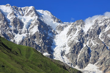 Landscape views of the Caucasus Mountains, river and villages. Peak and river Enguri. Georgia. Summer. 2019