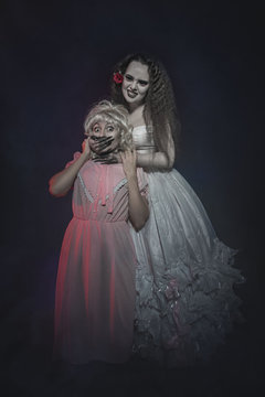Terrible zombie woman in white dress and her victim. Halloween scene