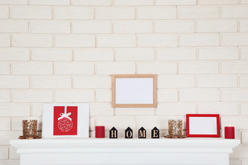 White fireplace with photo frames, candles and word Home