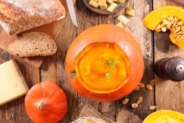 pumpkin soup in bowl with bread and cheese