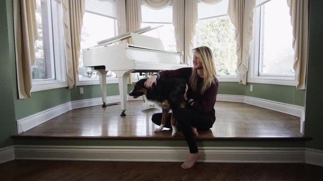 Pretty blonde girl with her dog in beautiful living room piano