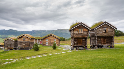 Fototapeta na wymiar Traditional wooden houses with roof covered with grass, plants and flowers in Oppdal in Norway, Scandinavia