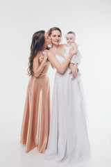 Fototapeta na wymiar wedding fashion concept for women of all ages. A group of women in long evening dresses on a white background