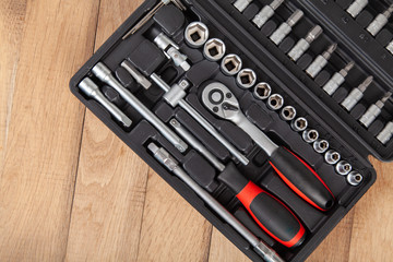 Tool set for machine repair, on wooden background. Car toolbox