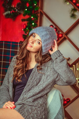 girl in a sweater and hat, on a Christmas background. Merry Christmas and happy new year Adorable...