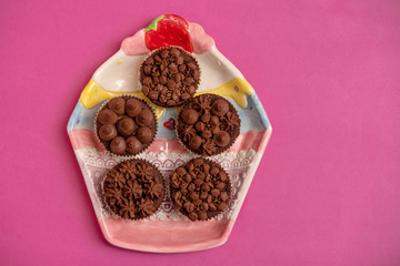 five cupcakes on a cupcake plate on pink background