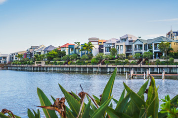  Wide panoramic view of Emerald Lakes residences across the lake, on a blue sky background during a...