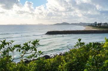 Stunning view of the Pacific Ocean and surfers catching waves in Tallebudgera Creek, visible from the Burleigh Head National Park on Gold Coast, Australia.