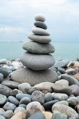 Obraz na płótnie Canvas Stack of white pebbles stone against blue sea background for spa, balance, meditation and zen theme.