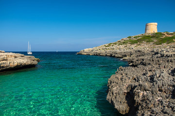Fototapeta na wymiar View on the beach Calo Roig and the Defense Tower Alcaufar on Menorca.