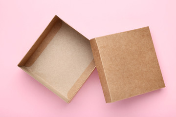 Open brown gift box on pink background