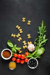 Ingredients for italian farfalle pasta. Recipe. Raw materials for cooking on a black background