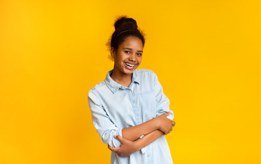 Beautiful teen girl posing to camera with folded arms